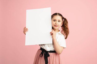 Pembe stüdyo arka planında kopyalanmış beyaz kız portresi.