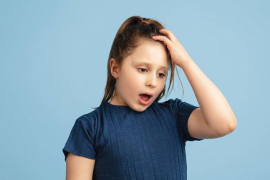 Mavi stüdyo arka planında kopyalanmış beyaz kız portresi.