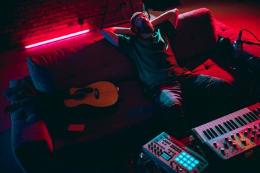 Müzisyenlerin neon ışıkta performans sergilediği yakın çekim. Reklam, hobi, müzik, festival, eğlence kavramı.