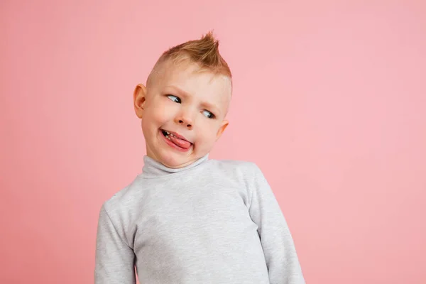 Rapaz feliz isolado no fundo do estúdio rosa. Parece feliz, alegre, sincero. Espaço de cópia. Infância, educação, conceito de emoções — Fotografia de Stock