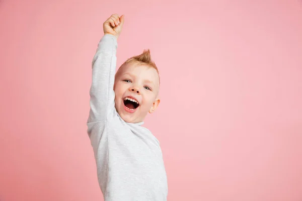 Glücklicher Junge isoliert auf rosa Studiohintergrund. Sieht glücklich, fröhlich, aufrichtig aus. Kopierraum. Kindheit, Bildung, Emotionen — Stockfoto