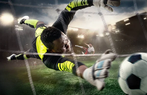 Fútbol africano masculino o jugador de fútbol, portero en acción en el estadio. Joven atrapando pelota, entrenando, protegiendo objetivos en movimiento. — Foto de Stock