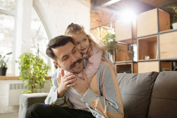 Gelukkige vader en kleine schattige dochter thuis. Familie tijd, gehamer, ouderschap en gelukkige kindertijd concept. Weekend met oprechte emoties. — Stockfoto