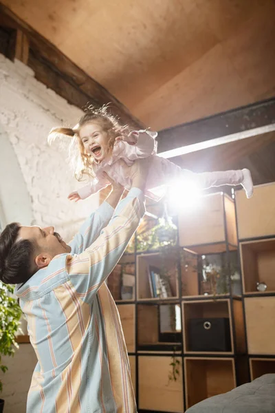 Gelukkige vader en kleine schattige dochter thuis. Familie tijd, gehamer, ouderschap en gelukkige kindertijd concept. Weekend met oprechte emoties. — Stockfoto