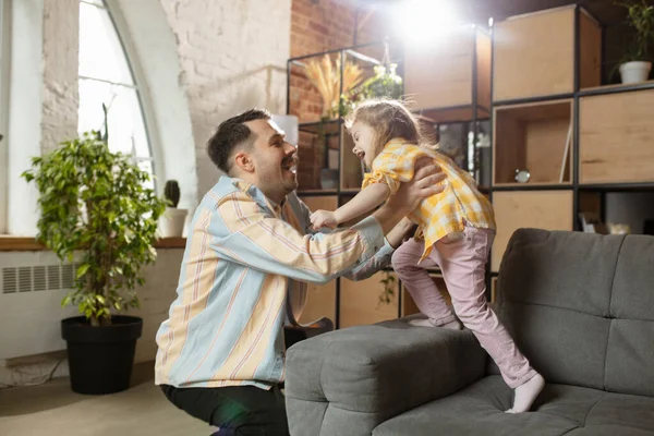 Gelukkige vader en kleine schattige dochter thuis. Familie tijd, gehamer, ouderschap en gelukkige kindertijd concept. Weekend met oprechte emoties. — Stockfoto