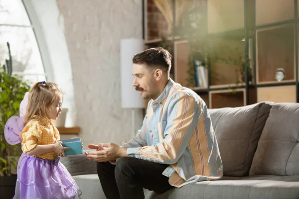 Gelukkige vader en kleine schattige dochter thuis. Familie tijd, gehamer, ouderschap en gelukkige kindertijd concept. Weekend met oprechte emoties. — Stockfoto