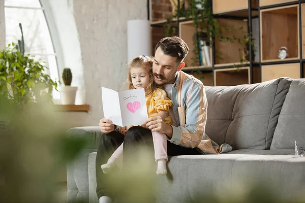 Gelukkige vader en kleine schattige dochter thuis. Familie tijd, gehamer, ouderschap en gelukkige kindertijd concept. Weekend met oprechte emoties. — Stockfoto