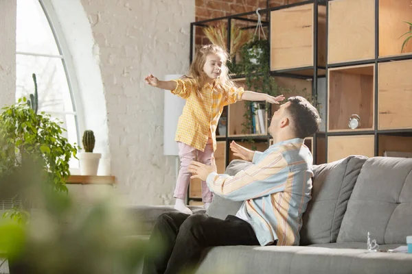 Gelukkige vader en kleine schattige dochter thuis. Familie tijd, gehamer, ouderschap en gelukkige kindertijd concept. Weekend met oprechte emoties. — Stockfoto