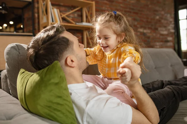 Gelukkige vader en kleine schattige dochter thuis. Familie tijd, gehamer, ouderschap en gelukkige kindertijd concept. Weekend met oprechte emoties. — Stockfoto