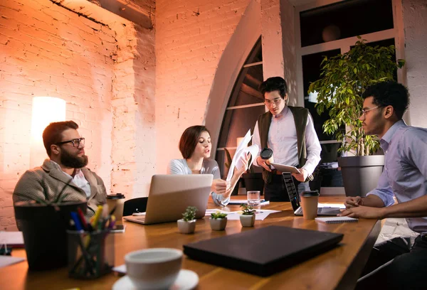 Kollegaer som samarbeider på moderne kontor ved hjelp av apparater og innretninger under kreativt møte – stockfoto