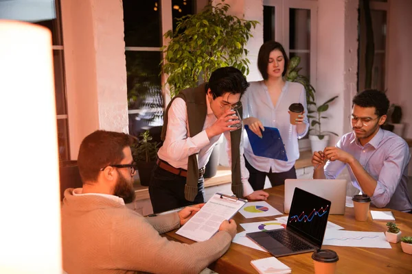 Colegas trabalhando juntos no escritório moderno usando dispositivos e gadgets durante a reunião criativa — Fotografia de Stock