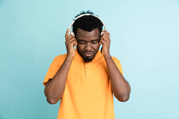 African mans portrait isolated over blue studio background with copyspace