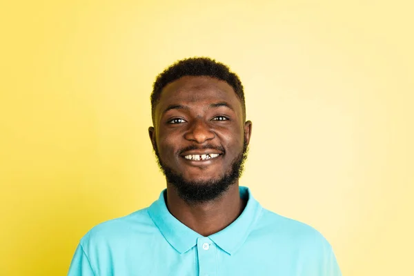 Portrait de jeune homme africain isolé sur fond de studio jaune avec copyspace. — Photo