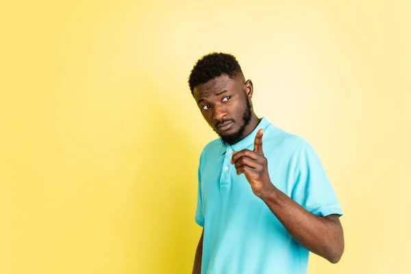 Retrato de un joven africano aislado sobre fondo de estudio amarillo con copyspace. —  Fotos de Stock