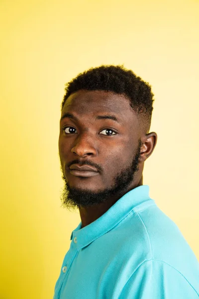 Retrato de un joven africano aislado sobre fondo de estudio amarillo con copyspace. — Foto de Stock