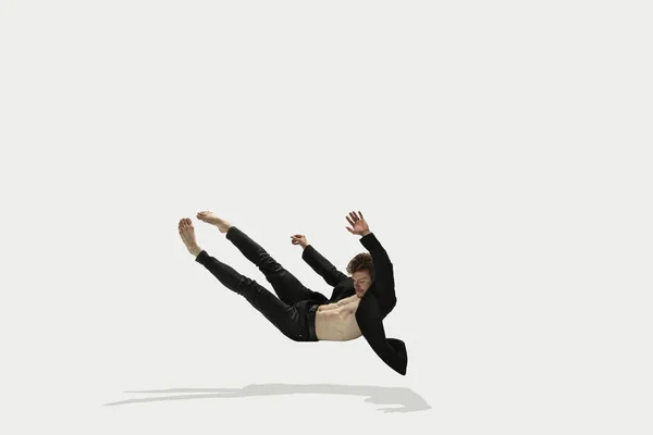 Pria dengan pakaian santai melompat dan menari terisolasi di latar belakang putih. Seni, gerak, aksi, fleksibilitas, konsep inspirasi. Penari balet Kaukasia yang fleksibel. — Stok Foto