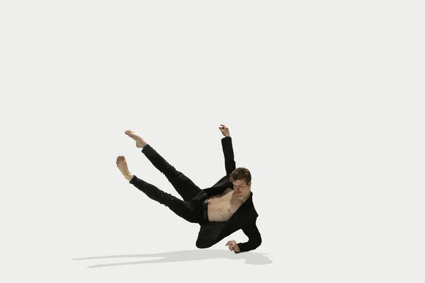 Man in casual stijl kleding springen en dansen geïsoleerd op witte achtergrond. Kunst, beweging, actie, flexibiliteit, inspiratie. Flexibele Kaukasische balletdanser. — Stockfoto