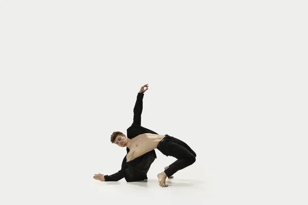 Man i avslappnad stil kläder hoppa och dansa isolerad på vit bakgrund. Konst, rörelse, handling, flexibilitet, inspirationskoncept. Flexibel kaukasisk balettdansare. — Stockfoto