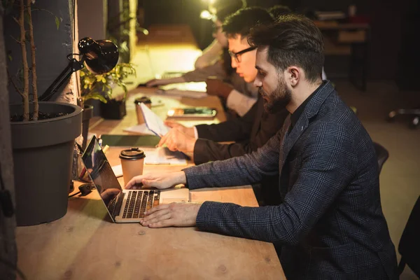 Colegas trabalhando juntos no escritório moderno usando dispositivos e gadgets durante a reunião criativa — Fotografia de Stock