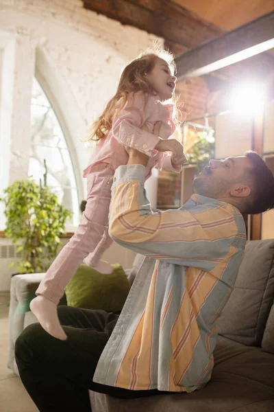 Lachend. Gelukkige vader en kleine schattige dochter thuis. Familie tijd, gehamer, ouderschap en gelukkige kindertijd concept. Weekend met oprechte emoties. — Stockfoto