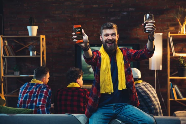 Grupo de amigos viendo la televisión, deporte partido juntos. Hombre emocional animando al equipo favorito, celebrando las apuestas exitosas. Concepto de amistad, actividad de ocio, emociones — Foto de Stock