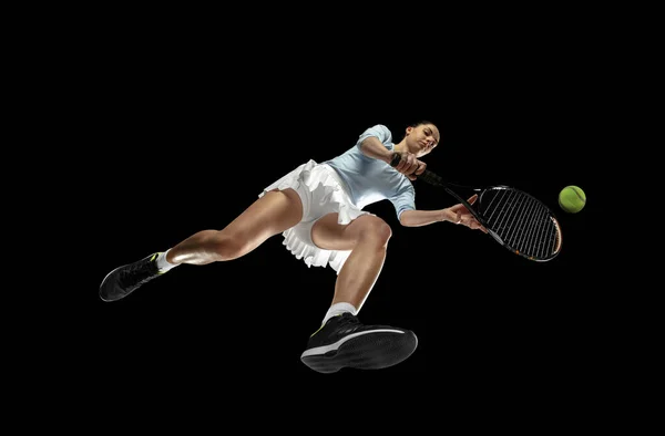 Női profi teniszező akcióban, mozgás elszigetelt fekete háttér, nézd meg alulról. A sport, a mozgás, az energia és a dinamika fogalma. — Stock Fotó