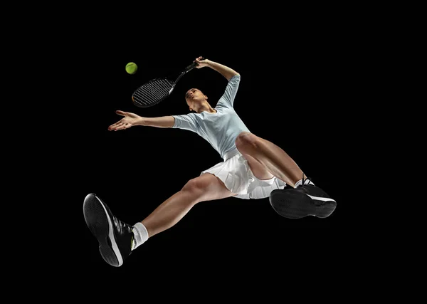 Žena profesionální tenista v akci, pohyb izolovaný na černém pozadí, podívejte se zdola. Pojetí sportu, pohybu, energie a dynamiky. — Stock fotografie