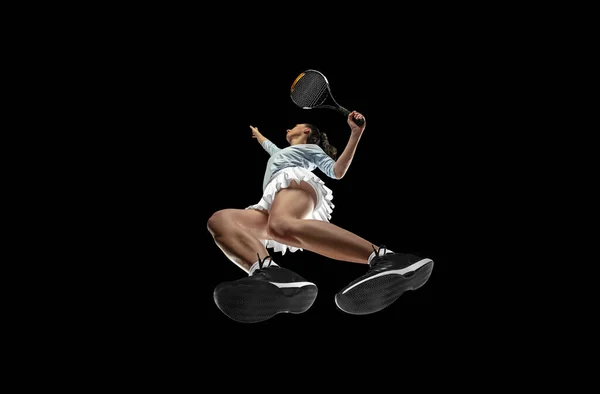 Tennisspielerin in Aktion, Bewegung isoliert auf schwarzem Hintergrund, Blick von unten. Konzept aus Sport, Bewegung, Energie und Dynamik. — Stockfoto