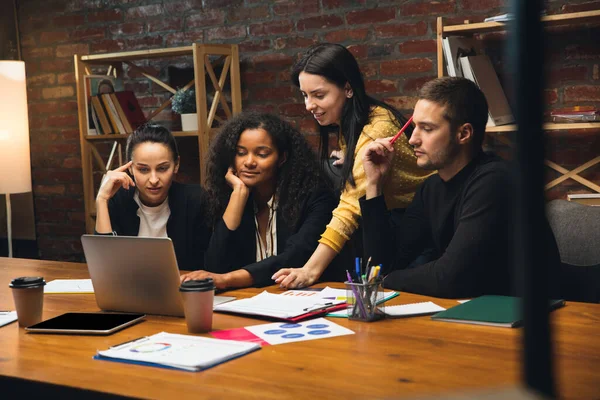 Collèges travaillant ensemble dans un bureau moderne en utilisant des appareils et des gadgets lors d'une réunion créative — Photo