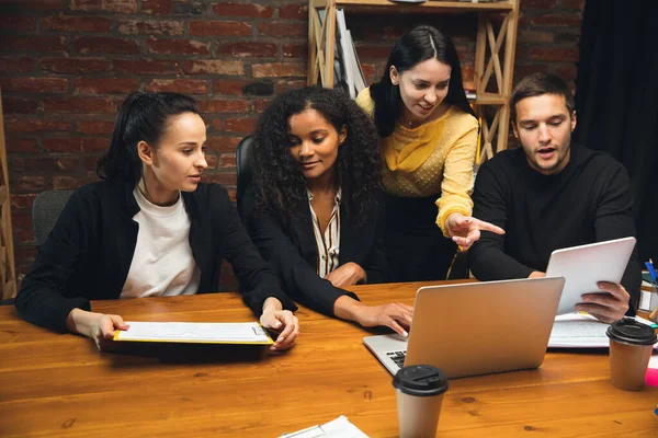 Colegas trabajando juntos en la oficina moderna utilizando dispositivos y dispositivos durante la reunión creativa — Foto de Stock