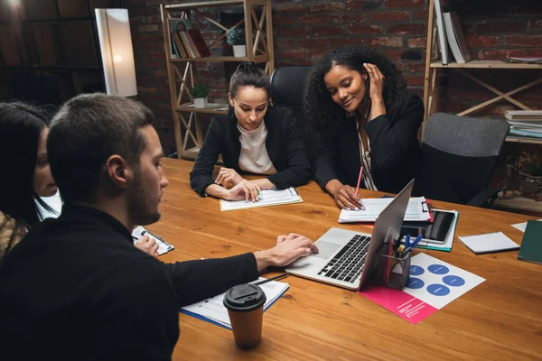 Collèges travaillant ensemble dans un bureau moderne en utilisant des appareils et des gadgets lors d'une réunion créative — Photo