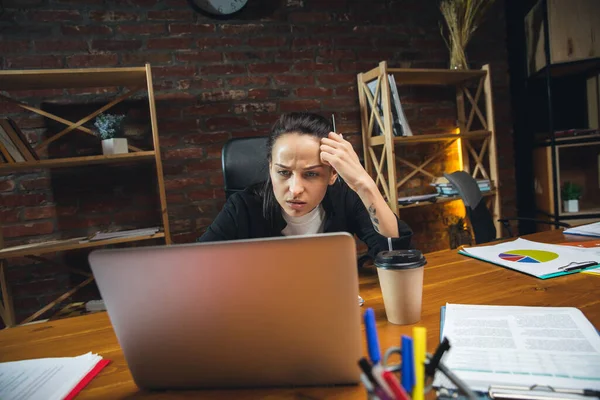 Jovem mulher trabalhando no escritório moderno usando dispositivos e gadgets. Elaboração de relatórios, análises, tarefas de processamento de rotina — Fotografia de Stock