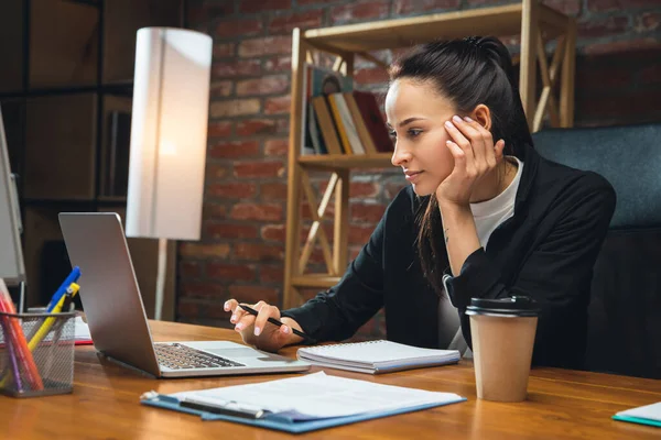 Junge Frau arbeitet im modernen Büro mit Geräten und Gadgets. Berichte, Analysen, Routinearbeiten — Stockfoto