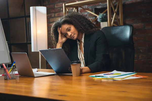 Mujer joven que trabaja en la oficina moderna utilizando dispositivos y dispositivos. Realización de informes, análisis, tareas rutinarias de procesamiento — Foto de Stock