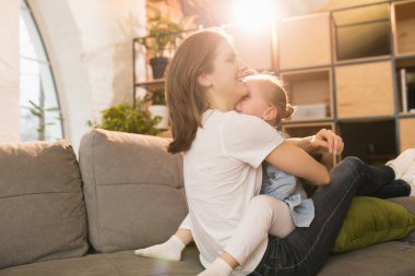 Aile zamanı. Anne ve kızı evde birlikte vakit geçiriyorlar, mutlu ve samimi görünüyorlar.