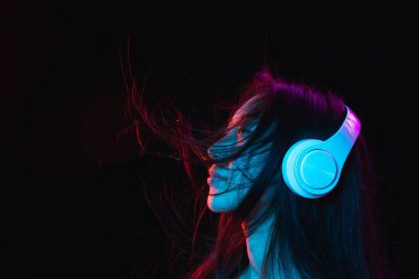 Asyalı genç kadınların Neon 'daki karanlık stüdyo arka planındaki portresi. İnsan duyguları kavramı, yüz ifadesi, gençlik, satış, reklam.