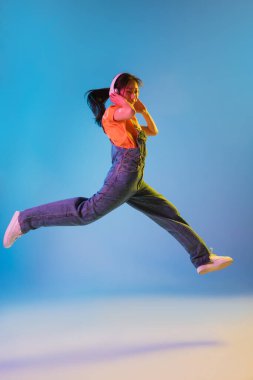 Mavi stüdyo arka planında Neon 'da Asyalı genç kadın portresi. İnsan duyguları kavramı, yüz ifadesi, gençlik, satış, reklam.