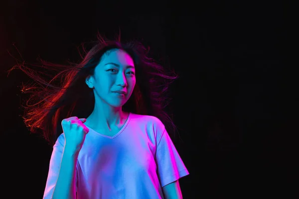 Asiatische junge Frauen porträtieren auf dunklem Studiohintergrund in Neon. Konzept menschlicher Emotionen, Mimik, Jugend, Verkauf, Werbung. — Stockfoto