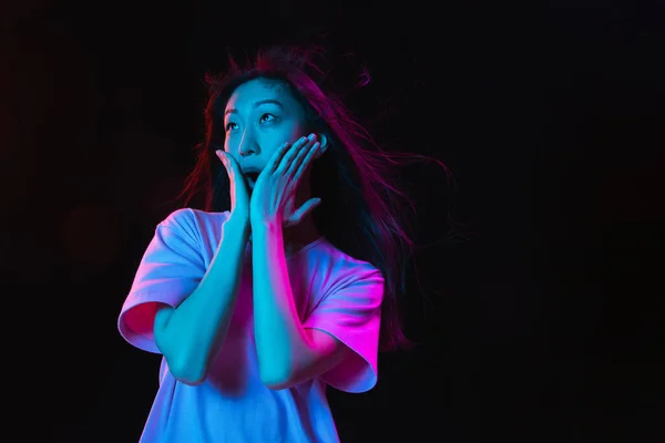 Asiatica giovane donna ritratto su sfondo scuro studio in neon. Concetto di emozioni umane, espressione facciale, gioventù, vendite, annuncio. — Foto Stock