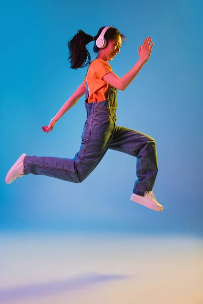 Asiatiska unga kvinnor porträtt på blå studio bakgrund i neon. Begreppet mänskliga känslor, ansiktsuttryck, ungdom, försäljning, annons. — Stockfoto