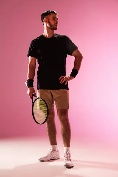 Ung kaukasier man spelar tennis isolerad på rosa studio bakgrund, action och motion koncept — Stockfoto