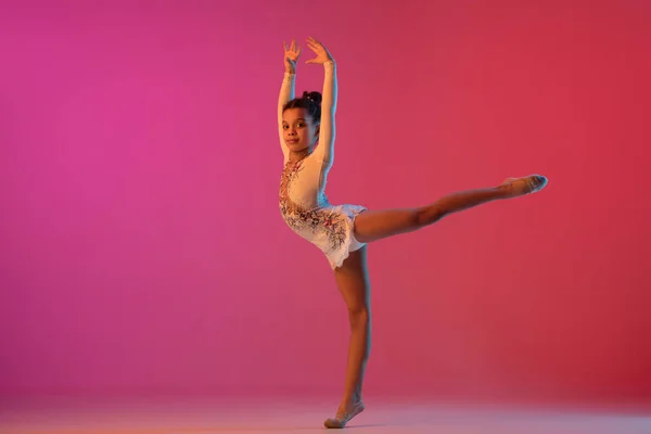 Gimnasta rítmica afroamericana, chica bonita practicando en gradiente fondo de estudio en luz de neón —  Fotos de Stock