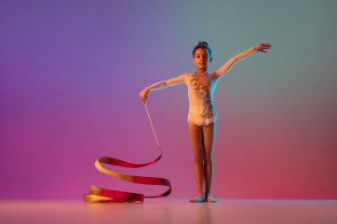 Afro-Amerikan ritmik jimnastikçi, güzel kız neon ışıklarıyla gradyan stüdyoda pratik yapıyor.