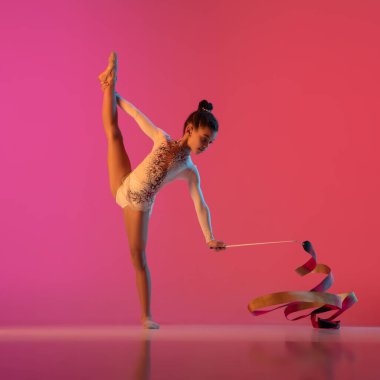 Afro-Amerikan ritmik jimnastikçi, güzel kız neon ışıklarıyla gradyan stüdyoda pratik yapıyor.