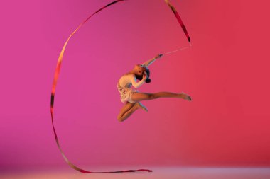 Afro-Amerikan ritmik jimnastikçi, güzel kız neon ışıklarıyla gradyan stüdyoda pratik yapıyor.