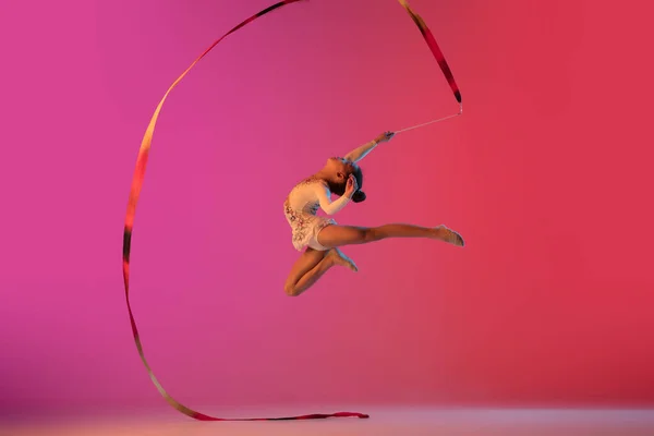 Ginnasta ritmica afro-americana, bella ragazza che pratica su sfondo gradiente in studio in luce al neon — Foto Stock