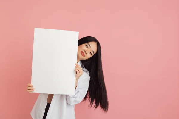 在粉红工作室背景上的亚洲年轻女性肖像。人类情感、面部表情、青春、销售、广告的概念. — 图库照片