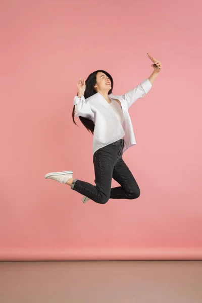 Retrato de mujeres jóvenes asiáticas sobre fondo de estudio rosa. Concepto de emociones humanas, expresión facial, juventud, ventas, anuncio. —  Fotos de Stock