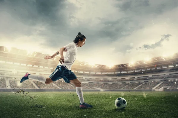 Calcio maschile, giocatore di calcio cattura palla in salto allo stadio durante la partita di sport su sfondo cielo scuro — Foto Stock