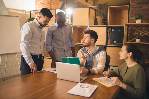 Colleghi che lavorano insieme in un ufficio moderno utilizzando dispositivi e gadget durante l'incontro creativo — Foto Stock